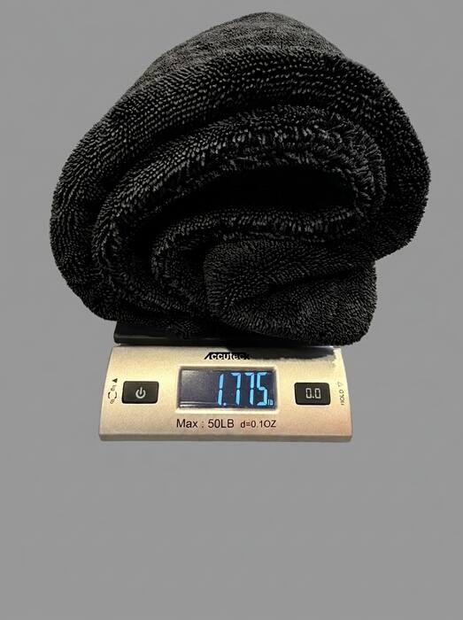 The Ducking Wet 1400 GSM black towel on an Accuteck digital postal scale — the display reads 1.775 lb (we round down to 1.7+ lb on the site)